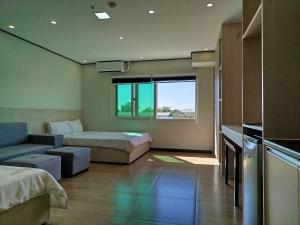 um quarto com uma cama, um sofá e uma janela em Emmaus condotel em Angeles