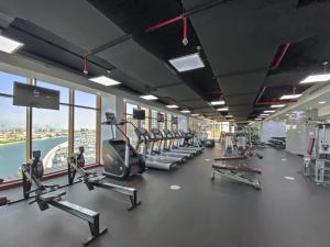 een fitnessruimte met loopbanden en cardio-apparatuur in een gebouw bij Silkhaus majestic studio with sea view Palm Jumeirah in Dubai