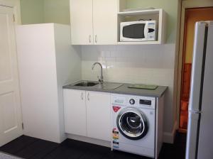 a kitchen with a washing machine and a microwave at Donalea Bed and Breakfast & Riverview Apartment in Castle Forbes Bay