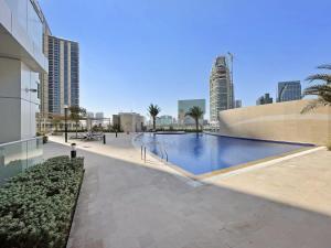 a swimming pool in a city with tall buildings at Silkhaus Al Reem island Modern 1BDR in Abu Dhabi