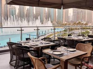 a restaurant with tables and chairs and a fountain at Silkhaus chic 1BDR with patio near Burj Khalifa in Dubai