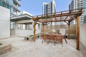 a patio with a wooden pergola and a wooden table at Silkhaus Ideal for Big Family, 5BDR with Private Roof Top in Dubai