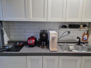 a kitchen counter with a coffee maker next to a sink at Yolo House in Incheon