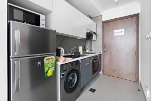a kitchen with a refrigerator and a washing machine at Silkhaus new studio in Art Gardens pool access in Dubai