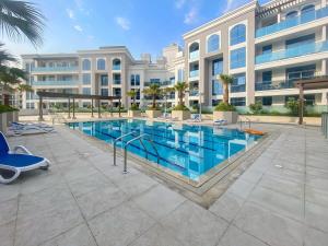 uma piscina em frente a um edifício em Silkhaus new studio in Art Gardens pool access no Dubai