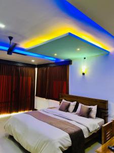 a bedroom with a large bed with blue lights on the ceiling at Greenview in Vythiri