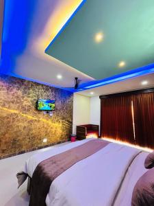 1 dormitorio con 1 cama grande y TV en la pared en Greenview en Vythiri