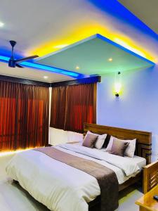 a bedroom with a large bed with a colorful ceiling at Greenview in Vythiri