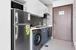 uma cozinha com um frigorífico de aço inoxidável e uma máquina de lavar louça em Chic Studio in Art Gardens Modern Living no Dubai