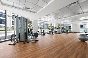 a gym with treadmills and exercise equipment in a building at Chic Studio in Art Gardens Modern Living in Dubai