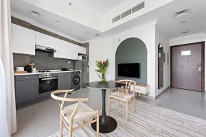 a kitchen with a table and chairs in a room at Silkhaus modern studio in Art Gardens in-house kitchen in Dubai