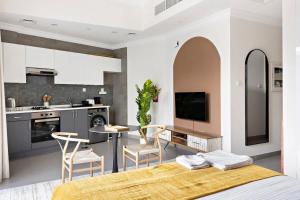 eine Küche und ein Wohnzimmer mit einem Tisch und Stühlen in der Unterkunft Silkhaus aesthetic studio in Art Gardens with gym & pool access in Dubai