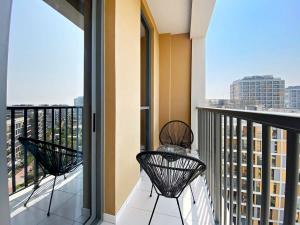 a balcony with two chairs and a view of a city at Silkhaus Luxury Studio Near Dubai Sport City in Dubai