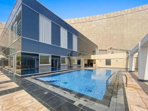 a swimming pool in front of a building at Silkhaus chic studio in Sky Gardens Pool & Gym in Dubai