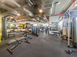 een fitnessruimte met diverse loopbanden en fitnessapparaten bij Silkhaus chic studio in Sky Gardens Pool & Gym in Dubai