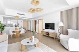 a living room with a couch and a tv and a table at Silkhaus Premium Luxury Unit by Aldar with Beach Access in Abu Dhabi
