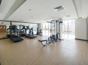 un gimnasio con varias cintas de correr y máquinas elípticas en Silkhaus New Pad with Pool & Gym near Reem Mall en Abu Dabi