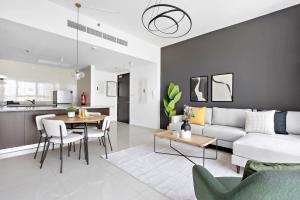 un soggiorno con divano e tavolo di Silkhaus Luxurious 1 BDR Al Fay Park Nearby a Abu Dhabi