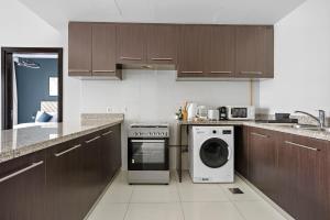 a kitchen with a washing machine and a dishwasher at Silkhaus Spacious 1 BDR Al Fay Park Nearby in Abu Dhabi