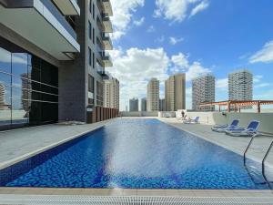 a swimming pool on the roof of a building at Silkhaus Spacious 2 BDR Reem Central Park Nearby in Abu Dhabi