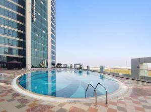 a large swimming pool on top of a building at Silkhaus Beautiful Studio Reem Park nearby in Abu Dhabi
