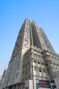 a tall building with a blue sky in the background at Silkhaus Modern 1 BDR Al Fay Park Nearby in Abu Dhabi