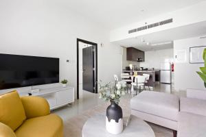 uma sala de estar com um sofá e uma televisão em Silkhaus New 1 BDR Al Fay Park Nearby em Abu Dhabi