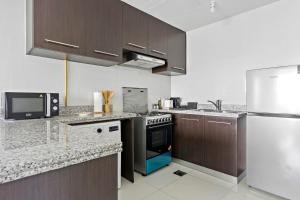 uma cozinha com um fogão e um frigorífico em Silkhaus New 1 BDR Al Fay Park Nearby em Abu Dhabi