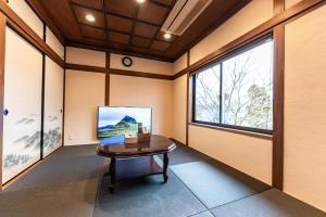 a room with a table and a large window at 完全貸切別荘 天然温泉 La Saison inn Kirishima 888 in Kirishima