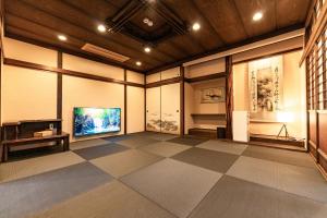 a large room with a television and a tiled floor at 完全貸切別荘 天然温泉 La Saison inn Kirishima 888 in Kirishima