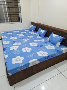 - un lit avec une couette et des oreillers bleus et blancs dans l'établissement Hanumant kripa geust house only for family, à Ujjain