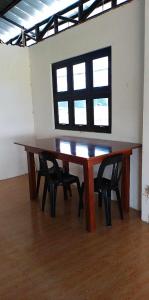 einen Holztisch mit Stühlen in einem Zimmer mit Fenster in der Unterkunft La Veranda Farm Breeze in Batuan