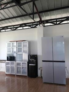 Zimmer mit einem weißen Kühlschrank und einem Regal in der Unterkunft La Veranda Farm Breeze in Batuan
