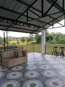 a couch on a patio with a table and chairs at La Veranda Farm Breeze in Batuan