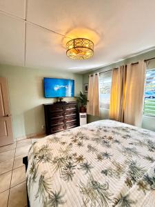 a bedroom with a bed and a flat screen tv at Unrivaled S Kihei Maui location! Walk to it all! in Kihei