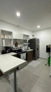 a large kitchen with a refrigerator and a stove at Sunset 302 in Antiguo Cuscatlán