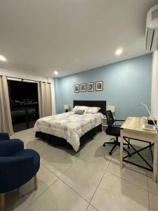 a bedroom with a bed and a desk and a table at Sunset 302 in Antiguo Cuscatlán