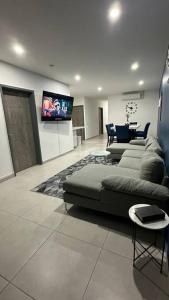 a living room with a couch and a flat screen tv at Sunset 302 in Antiguo Cuscatlán