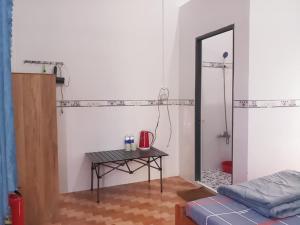 Zimmer mit einem Tisch, einem Spiegel und einem Bett in der Unterkunft Đức Phát Homestay in Tân Phú