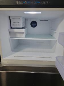einem leeren Kühlschrank mit offener Tür und Regalen in der Unterkunft Cozy home in Washington Heights in Chicago
