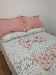 ein Bett mit zwei Paar rosa Schuhen drauf in der Unterkunft Casa em Condomínio Fechado in Pelotas