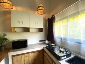 a small kitchen with a stove and a window at S&S House 2 in Koh Phangan