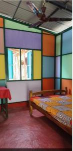a room with a bed with colorful walls and a ceiling at Peace and love stay in Alleppey
