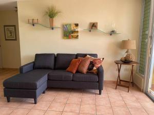 Una sala de estar con un sofá azul y una mesa. en Villas Del Mar Beach Resort, en Loiza