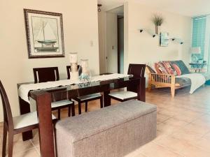 sala de estar con mesa, sillas y sofá en Villas Del Mar Beach Resort, en Loiza