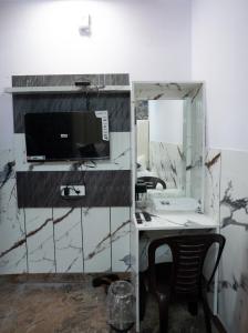 een kamer met een bureau, een computer en een spiegel bij Star@Hotel in New Delhi