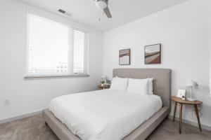 a white bedroom with a large bed and a window at CozySuites 1BR in Bottleworks Indy Unit #7 in Indianapolis