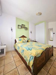 una camera da letto con un letto grande in una stanza di L'Eskalya *** avec jacuzzi et piscine partagée, vue océan a Saint-Joseph