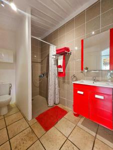 un bagno con un lavandino rosso e una doccia di L'Eskalya *** avec jacuzzi et piscine partagée, vue océan a Saint-Joseph