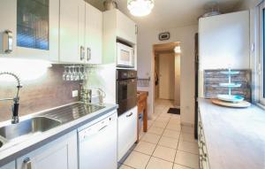 una cocina con armarios blancos y fregadero en Stunning Home In Pirou With Kitchen, en Pirou